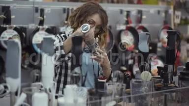 在电器商店里，一个穿着格子衬衫的漂亮卷发女人通过观看和拿着搅拌器棒